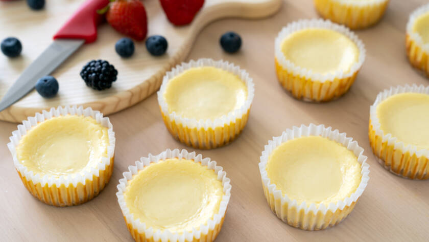 Mini cheesecake with blueberry, blackberry and strawberry ready to be served on wooden table